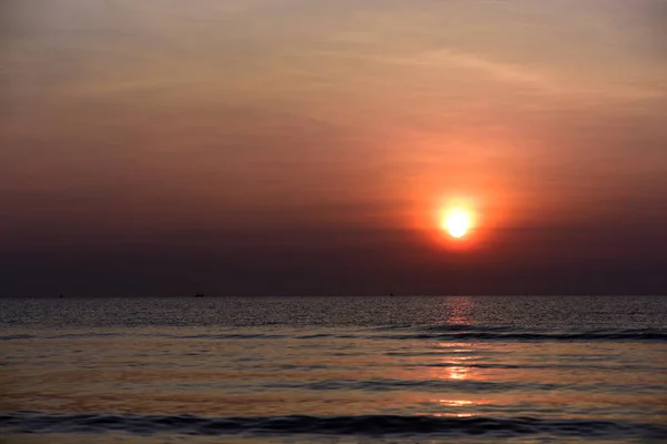 The view of the beach, the beach and the sun loungers are rising. Beautiful golden yellow sky and sun