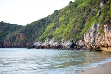 yemyeşil kayalıklar ve deniz dalgaları.