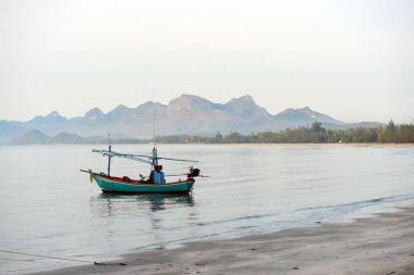 Sabahın erken saatlerinde sahilde park edilmiş plaj ve küçük balıkçı teknelerinin manzarası.