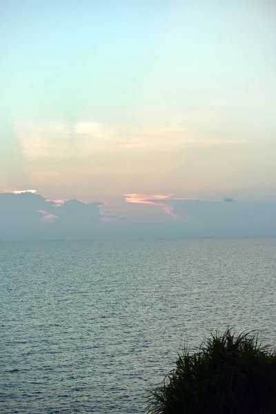 Denizde gün batımından sonra renkli gökyüzü manzarası Güzel bir bulutun arkasında parlayan ışık, arka plan görüntüsü olarak kullanılır