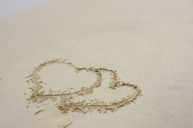 Sahildeki kumları boyayan kalplere yakın.