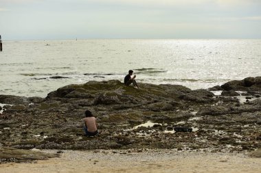 Deniz kıyısında dinlenen insanlar