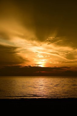 Güzel plaj manzarasında gün doğumu birçok insan gün batımından önce denizde oynamak için geliyor.plajda gün doğumu silueti.