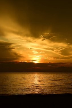 Güzel plaj manzarasında gün doğumu birçok insan gün batımından önce denizde oynamak için geliyor.plajda gün doğumu silueti.