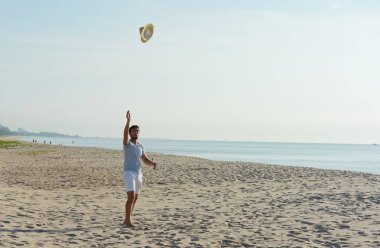 Sahilde dinlenen Asyalı adam.