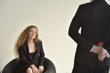 İşadamı iş kadınına kırmızı çiçek veriyor, işyerinde ilişki yaşıyor..