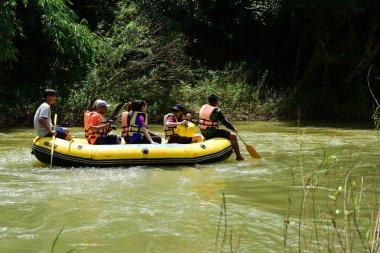 Tayland - 6 Ekim 2019: Bir grup turist yeşil ormanda nehirde kayak yapıyor. 