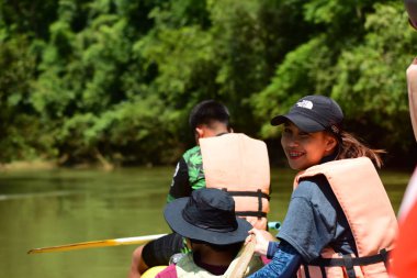 Tayland - 6 Ekim 2019: Bir grup turist yeşil ormanda nehirde kayak yapıyor. 
