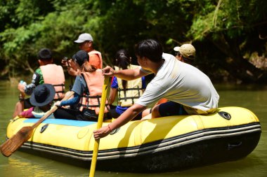 Tayland - 6 Ekim 2019: Bir grup turist yeşil ormanda nehirde kayak yapıyor. 