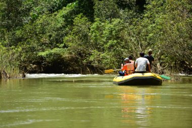 Tayland - 6 Ekim 2019: Bir grup turist yeşil ormanda nehirde kayak yapıyor. 