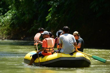 Tayland - 6 Ekim 2019: Bir grup turist yeşil ormanda nehirde kayak yapıyor. 