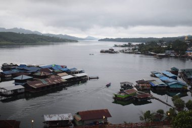 Yüzen evleri ve yelkenli tekneleri olan bir köy, Tayland.