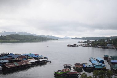 Yüzen evleri ve yelkenli tekneleri olan bir köy, Tayland.
