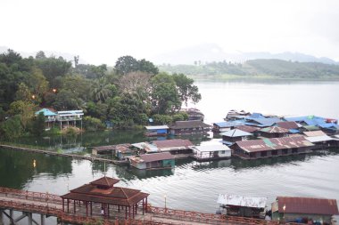 Yüzen evleri ve yelkenli tekneleri olan bir köy, Tayland.