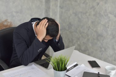 Ofiste dizüstü bilgisayarla çalışan Asyalı iş adamı