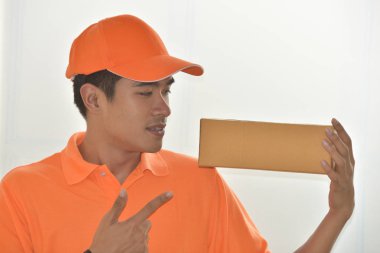 Turuncu üniformalı teslimatçı beyaz arka planda izole edilmiş. 