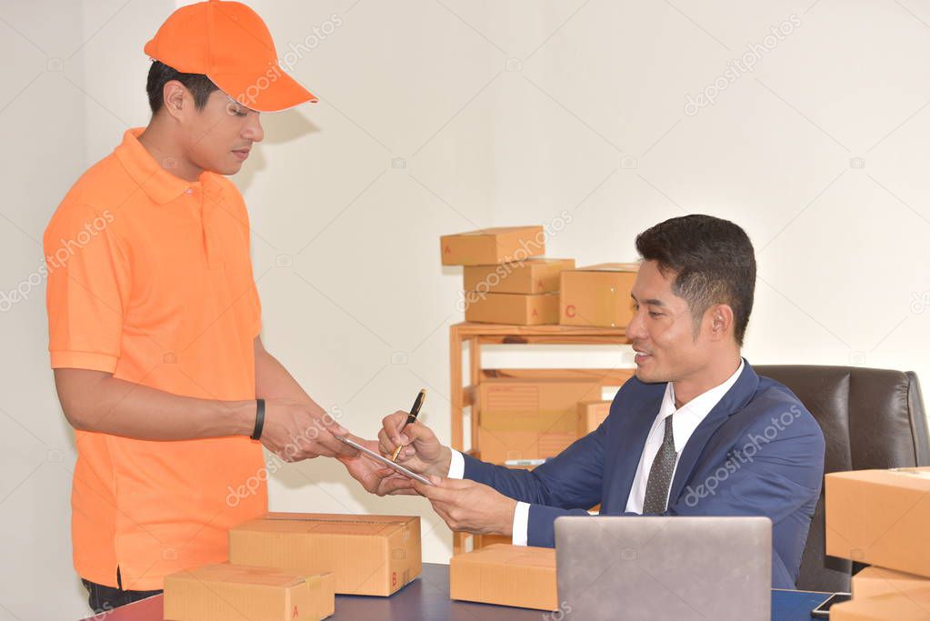 Delivery service concept, young asian worker in orange uniform delivering packages for businessman.
