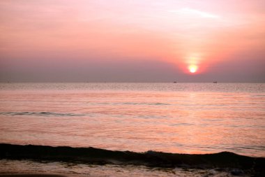 Deniz kenarında parlak gün batımı, renkli doğa..