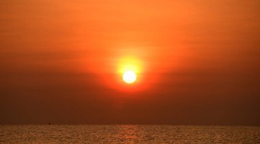 Deniz kenarında parlak gün batımı, renkli doğa..