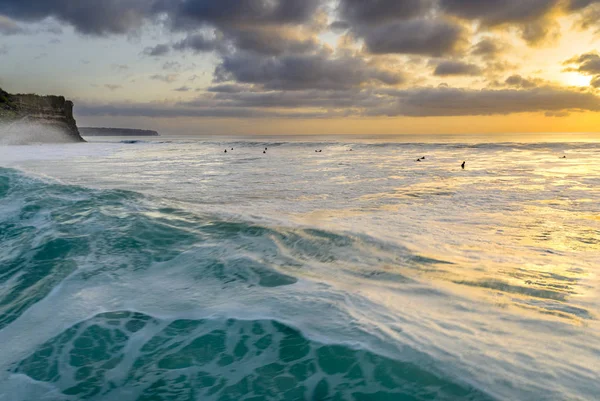 Серферы на закате в океане — стоковое фото