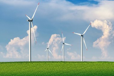 Yaz aylarında mavi gökyüzü ve beyaz bulutlar ile tarım alanında güneşli bir günde kırsal rüzgar enerjisi türbinleri