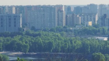 Dinyeper Nehri boyunca uzanan yemyeşil nehir kıyıları Kyiv 'in kentsel manzarasını, açık yaz gökyüzü altında yemyeşil yeşil alanlarda ortaya çıkan konut binalarıyla gözler önüne seriyor.