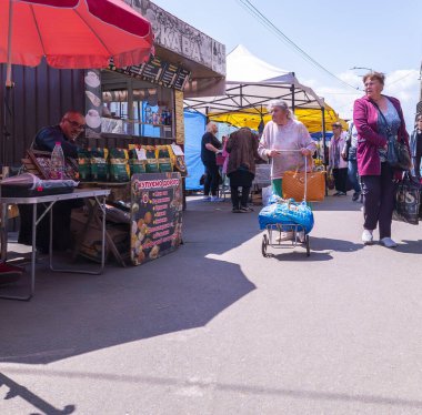 Kyiv, Ukrayna 3 Haziran 2025, Kyiv 'deki Bustling açık hava pazarı yaşlı kadınların şemsiyelerle ve açık hava stantlarıyla çevrili renkli tezgahlardan alışveriş yaptığı, günlük şehir hayatını yakaladığı yer.