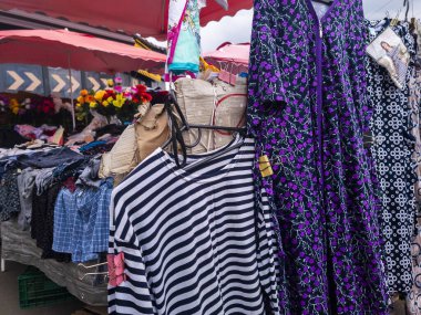 Kyiv, Ukraine 5th May,2025, Street market in Kyiv city with hanging clothes and colorful garments under umbrellas showcasing everyday urban life and local shopping atmosphere