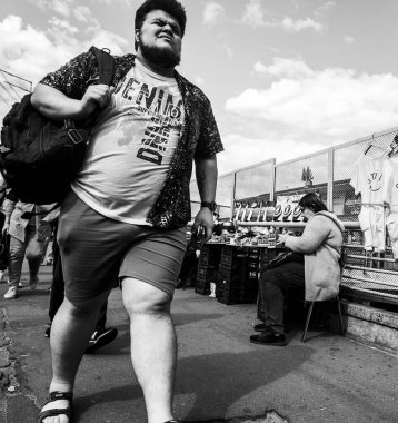 Kyiv, Ukraine 17th August,2025, Street market in Kyiv showing people in daily routines, with one man walking confidently in foreground and shoppers at outdoor stalls, portraying vibrant city life