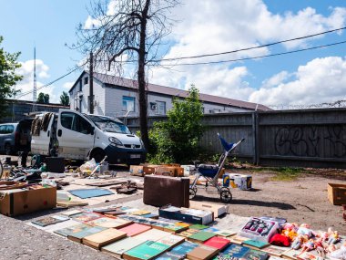 Kyiv, Ukraine 11th May,2025, Street flea market with old books, vintage toys, stroller and retro objects laid out on pavement under blue sky, showcasing secondhand bargains and urban nostalgia