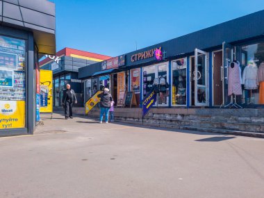 Kyiv, Ukraine 11th May,2025, Urban shopping center in Eastern Europe with storefronts, clothing displays, salon signs and people walking on a sunny day, reflecting everyday city lifestyle