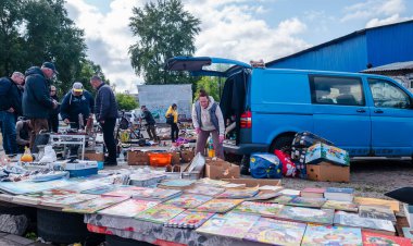 Kyiv, Ukraine 10th May,2025, Lively second hand street sale in Ukraine where people browse through used books, tools and vintage objects. Vendors set up goods on tables and from a blue van