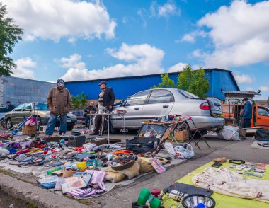 Kyiv, Ukraine 10th May,2025, Outdoor second hand market in Ukraine with vendors offering used clothes, electronics, tools, and household items. Shoppers browse bargains under bright blue skies