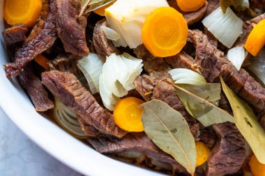 Et, havuç, soğan ve defne ile beyaz tabak..