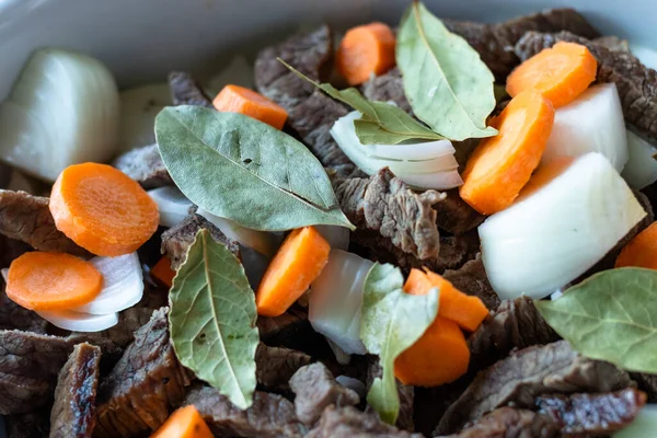 Siyah bir tavada et, havuç, soğan ve defne.. 