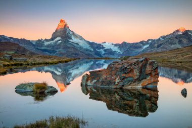 Matterhorn, İsviçre Alpleri. Gün doğumunda arka planda Stellisee ve Matterhorn olan İsviçre Alplerinin manzara resmi.