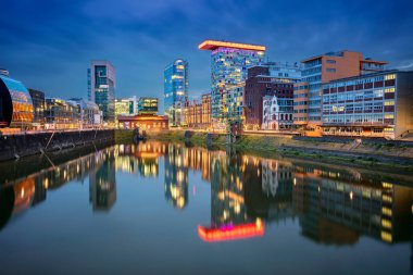 Düsseldorf, Almanya. Dsseldorf Cityscape görüntü, Almanya Medya Limanı ve Ren nehri şehrin yansıması ile, alacakaranlık mavi saat sırasında.