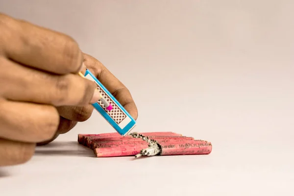 Burning crackers with hand concept using matchstick on isolated