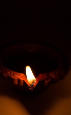 Evi diwali zamanlarda aydınlatma kullanılan Diwali Closeup pişmiş toprak diyas koyu arka plan üzerinde