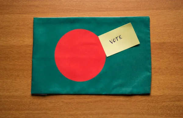 Voting concept - Hand Written Voting Sticker on Bangladesh Flag.