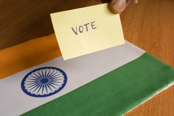 Concept de vote - Personne tenant la main autocollant de vote écrit sur le drapeau de l'Inde. — Photo