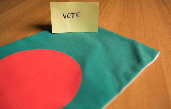 Concept de vote - Autocollant de vote écrit à la main sur le drapeau du Bangladesh . — Photo