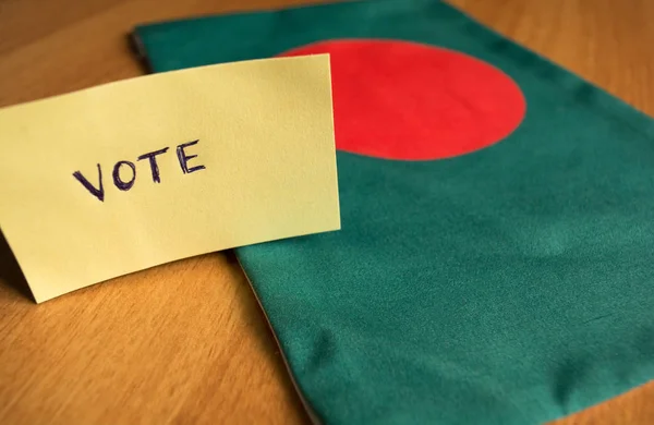 Abstimmungskonzept - handgeschriebener Wahlaufkleber auf Bangladesh-Flagge. — Stockfoto