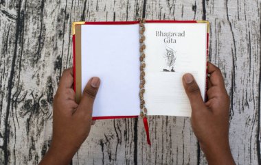 Maski, Karnataka, Hindistan - Aralık 29,2018: okuma Bhagavad Gita dokulu arka plan üzerinde elleriyle