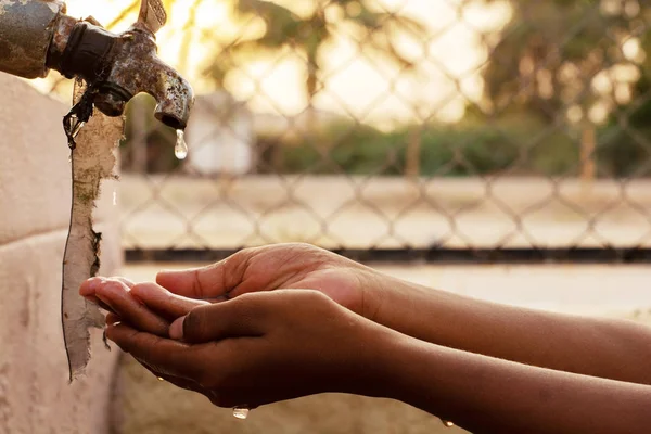 Nahaufnahme der Hände, Kind trinkt Wasser direkt aus dem Leitungswasser des Unternehmens in Indien — Stockfoto