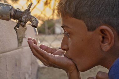 Maski, Karnataka, Hindistan - 26 Mart 2019: Hindistan 'daki kurumsal musluk suyundan Çocuk içme suyunun kapatılması