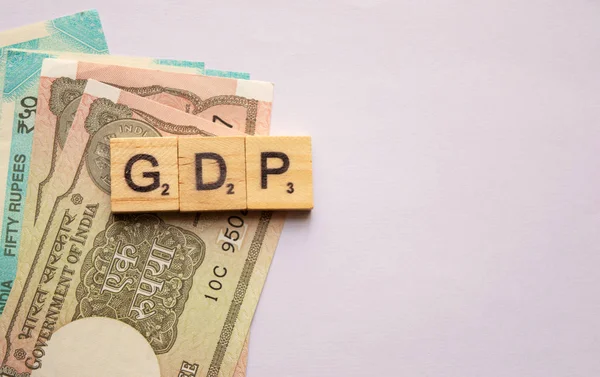 Maski, India 13 April 2019: PDB atau produk domestik bruto dalam huruf blok kayu dengan mata uang India pada latar belakang terisolasi . — Stok Foto