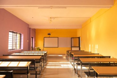 Empty class room and desks with colorful walls clipart