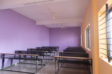 Renkli duvarlara sahip boş sınıf odası ve masaları