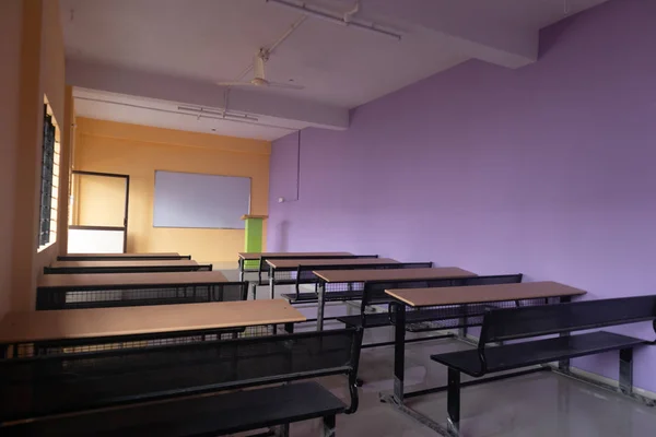 Порожня кімната класу і столи з різнокольоровими стінами — стокове фото